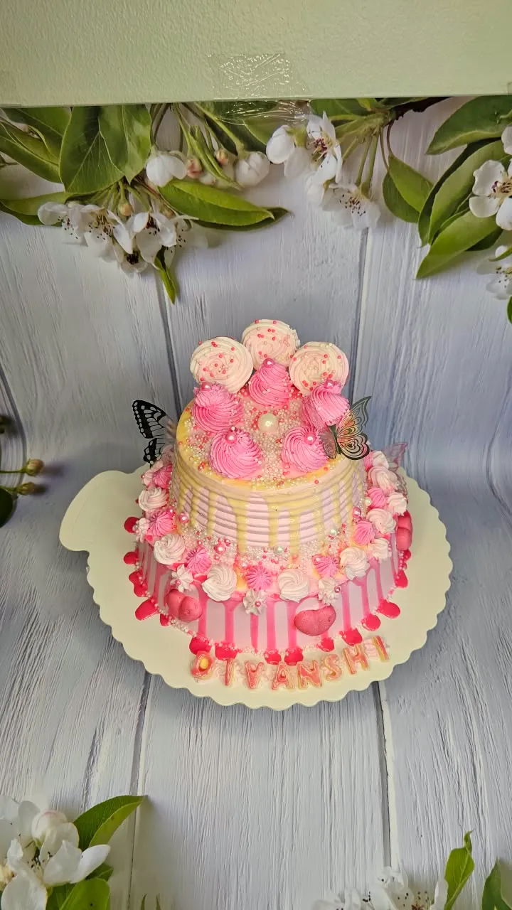 Pink butterfly birthday cake decorated with roses and buttercream