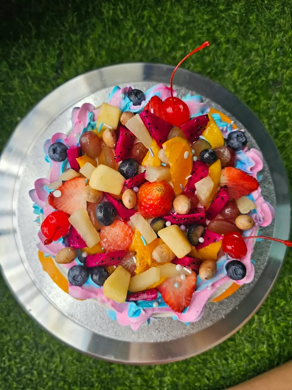 Bright celebration cake generously topped with fresh tropical fruit