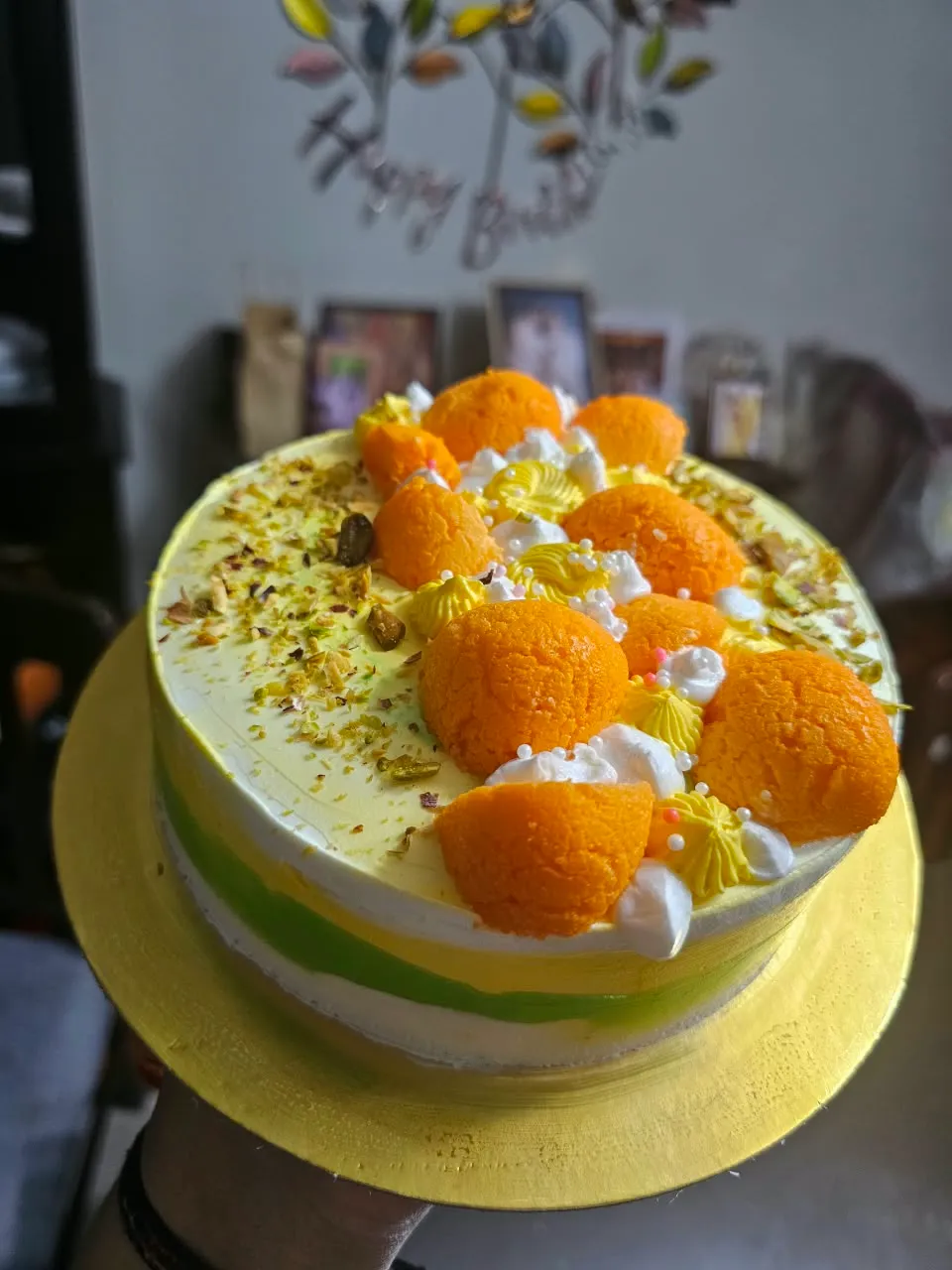 Yellow-and-green Indian-inspired celebration cake with traditional sweets