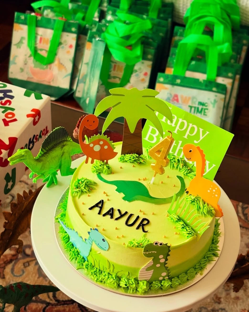 Green dinosaur-themed birthday cake made for a child’s celebration